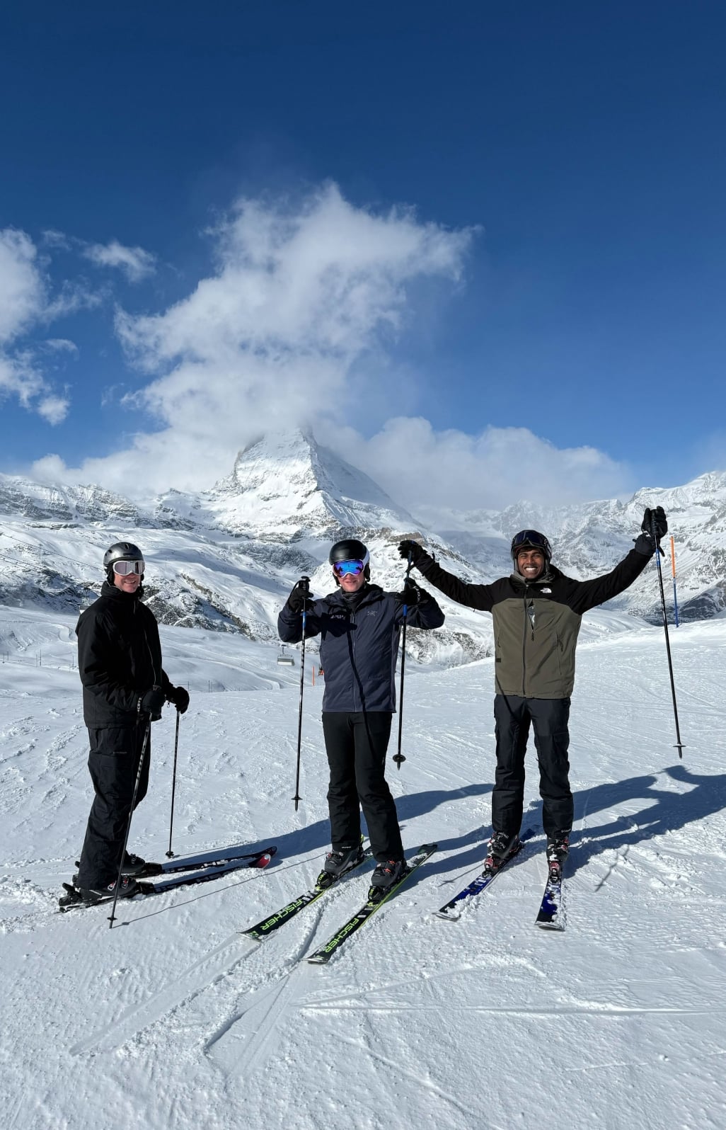Three skiers enjoying snowy mountain landscape