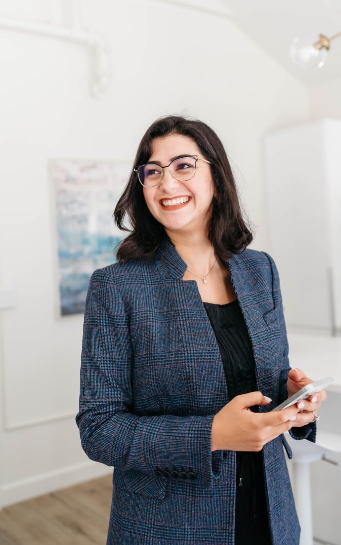 Smiling woman in business attire using phone