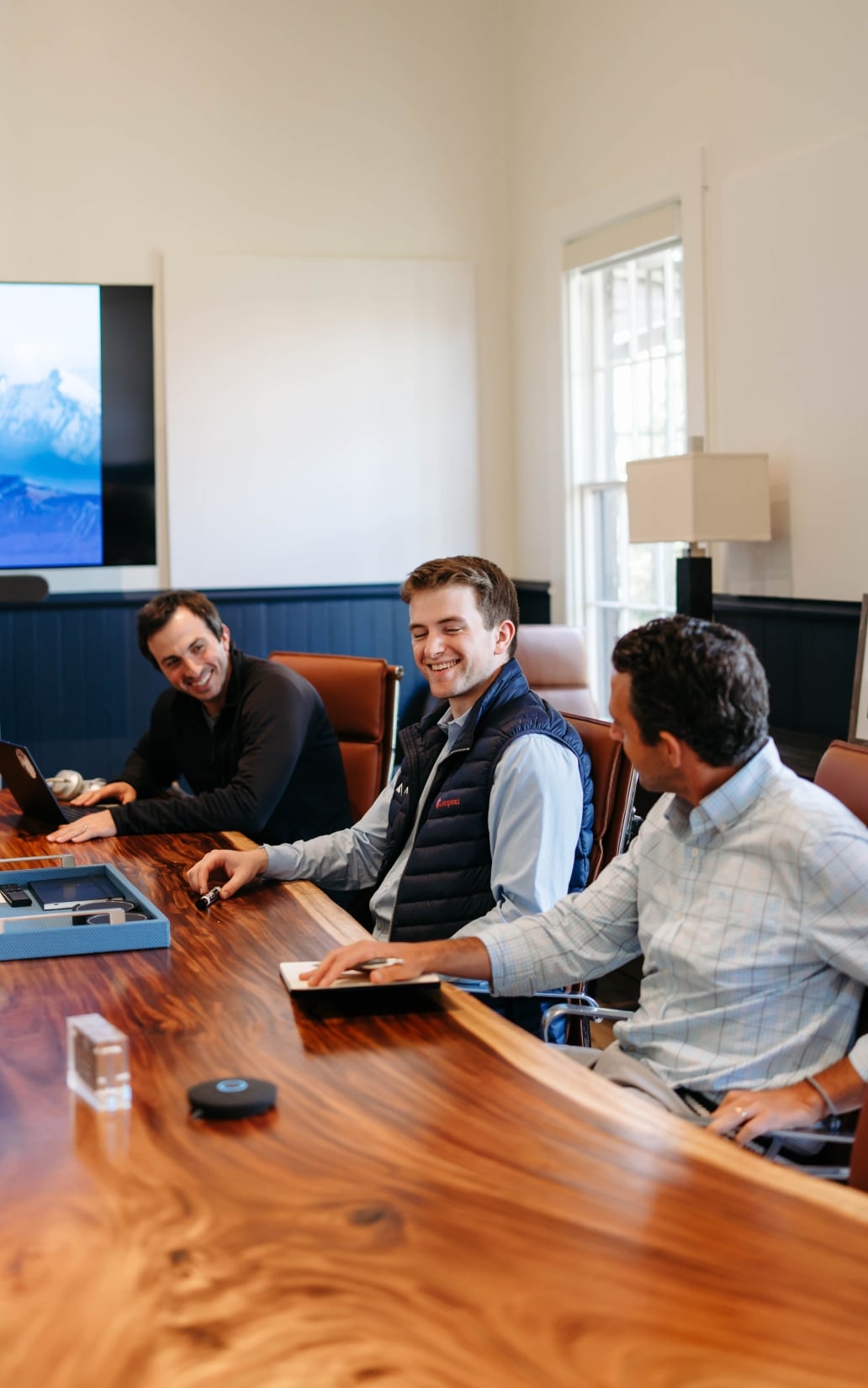 Business meeting with three men discussing strategy
