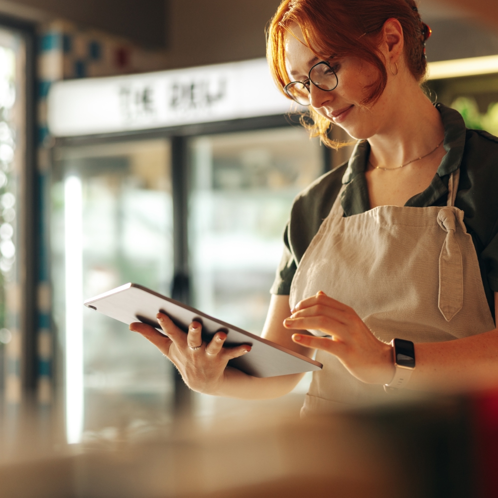 Woman using tablet at work wearing apron